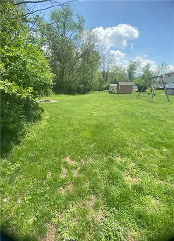 a view of a field with trees in the background