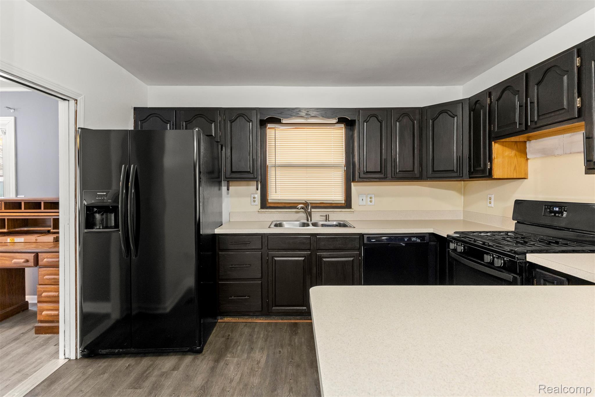 14716 Eureka Road Southgate, MI 48195 - Photo 14 of 42 Kitchen featuring black appliances, light countertops, and dark wood-style floors