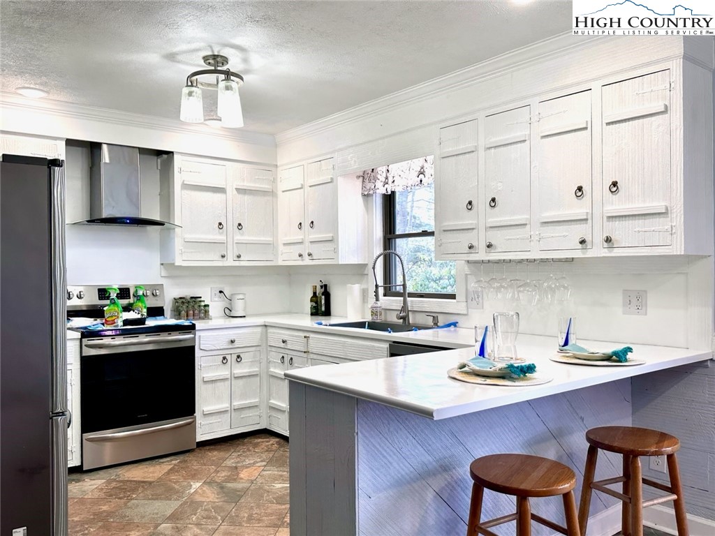 223 Timberlake Sparta, NC 28675 - Photo 11 of 50 a kitchen with stainless steel appliances granite countertop a sink a stove and cabinets