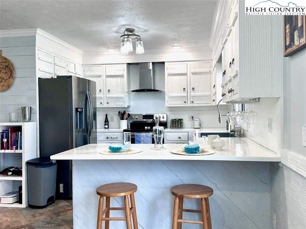223 Timberlake Sparta, NC 28675 - Photo 12 of 50 a kitchen with stainless steel appliances a sink a stove a refrigerator cabinets and a dining table