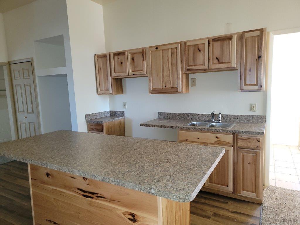 2034 County Rd LL Wiley, CO 81092 - Photo 17 of 29 a kitchen with a sink a microwave and cabinets