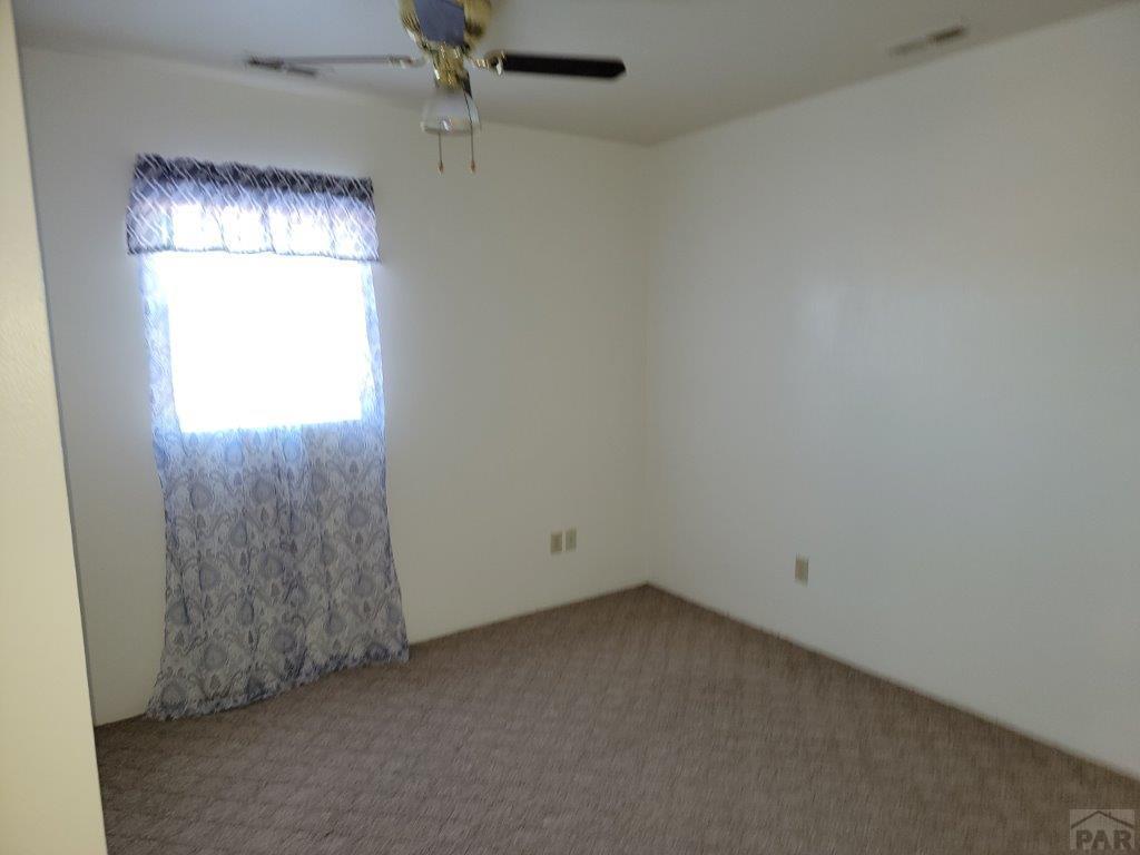 2034 County Rd LL Wiley, CO 81092 - Photo 22 of 29 an empty room with windows and chandelier fan