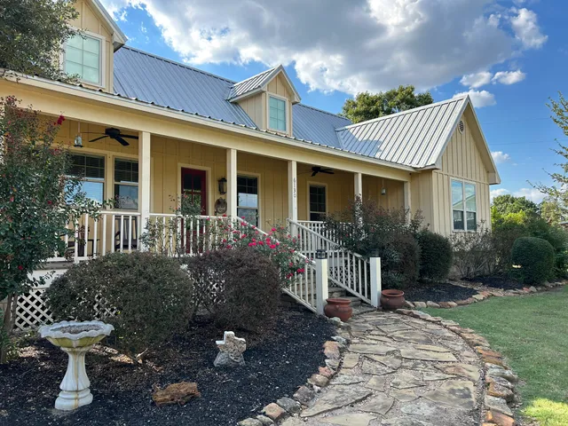 a view of a house with backyard and sitting area
