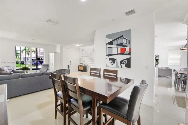a view of a dining room and livingroom with furniture wooden floor and a rug