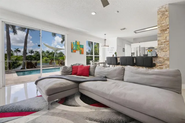 a living room with furniture and a floor to ceiling window