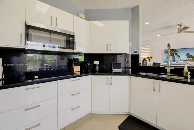 a kitchen with white cabinets and appliances