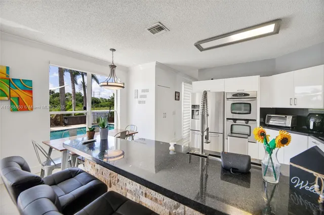 a view of a dining room with furniture a chandelier and wooden floor