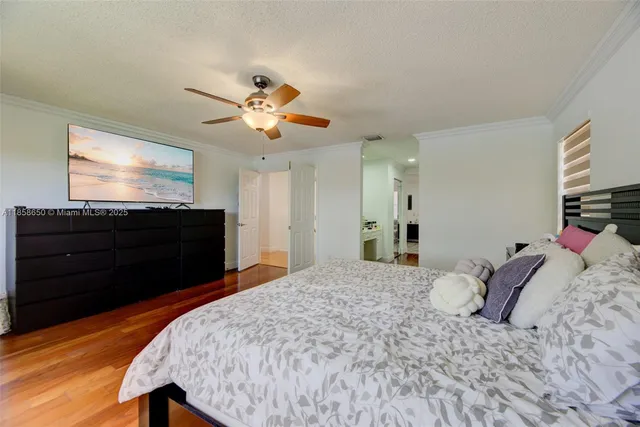a bedroom with a bed and a flat tv screen on dresser