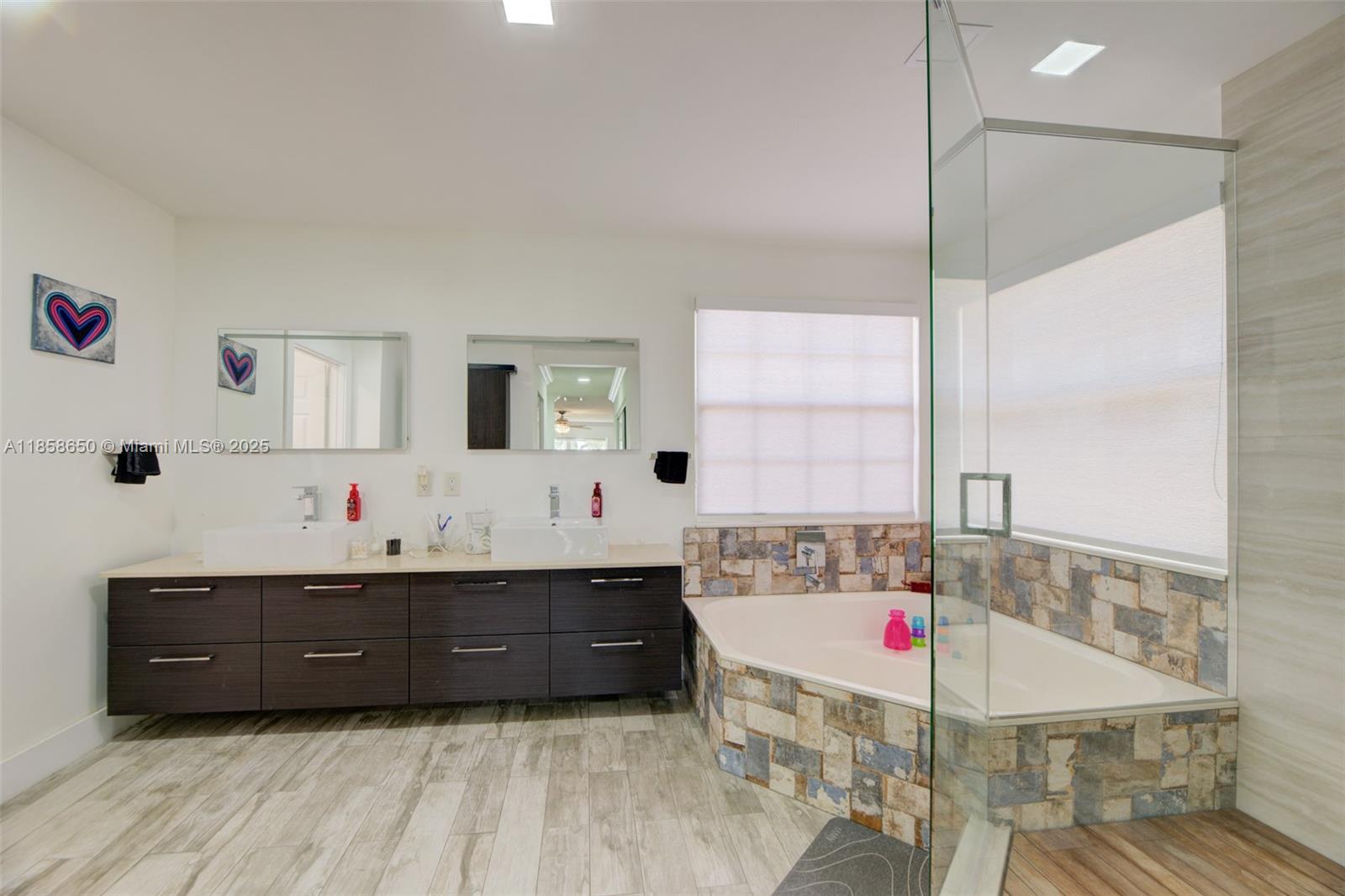 18196 Southwest 29th Street Miramar, FL 33029 - Photo 32 of 54 a bathroom with a tub sink vanity and mirror