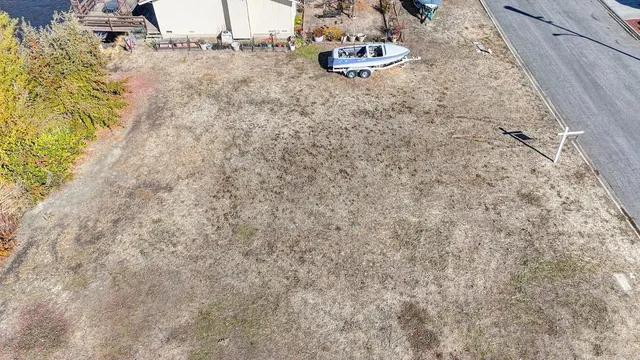 a view of a dry yard with wooden fence