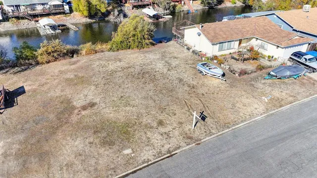 an aerial view of a house with a yard and lake view