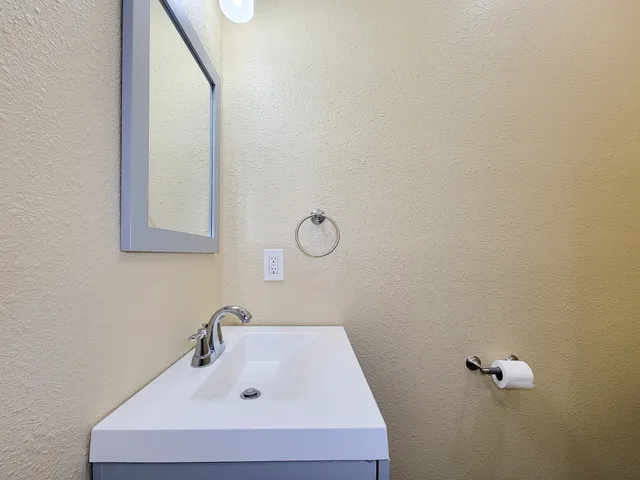 a bathroom with a sink and mirror with vanity