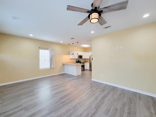 a view of a kitchen with a sink hardwood floor and a ceiling fan