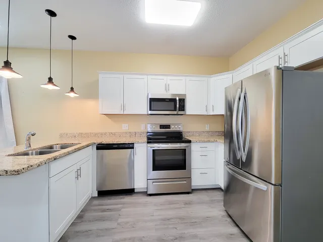 a kitchen with stainless steel appliances a refrigerator sink and microwave