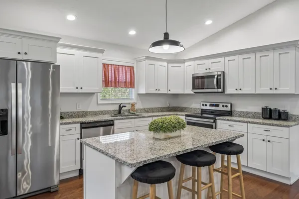 a kitchen with stainless steel appliances granite countertop a stove a refrigerator a sink a stove a microwave and island