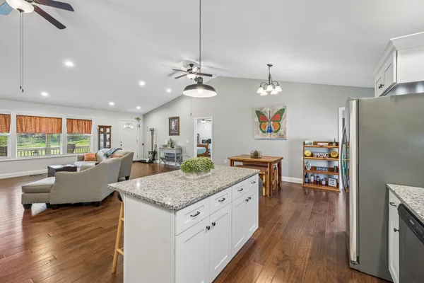 a view of kitchen center island dining table wooden floor and living room view