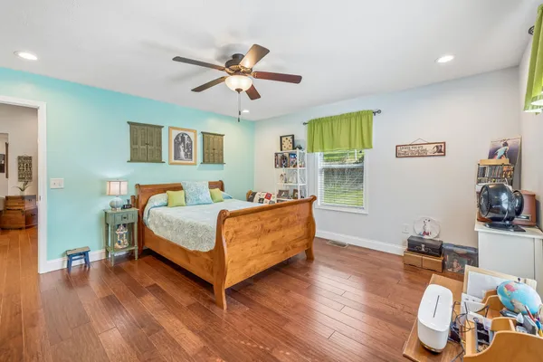 a bedroom with a bed and wooden floor