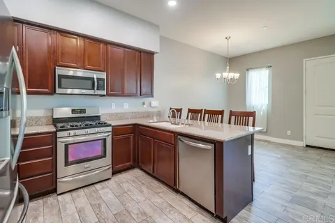 a kitchen with stainless steel appliances granite countertop a stove and a wooden cabinets