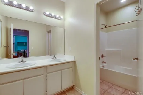 a bathroom with a sink double vanity granite tub and shower