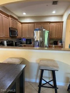 a kitchen with stainless steel appliances granite countertop a sink a microwave a stove and refrigerator