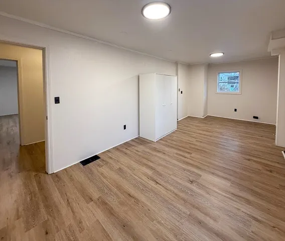 a view of empty room with wooden floor