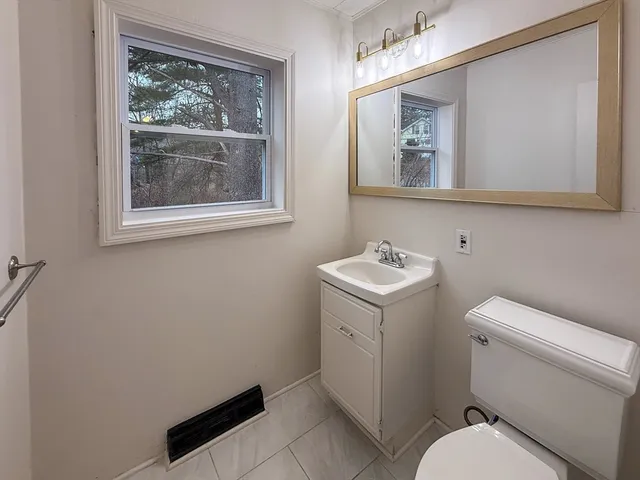 a bathroom with a toilet sink and mirror