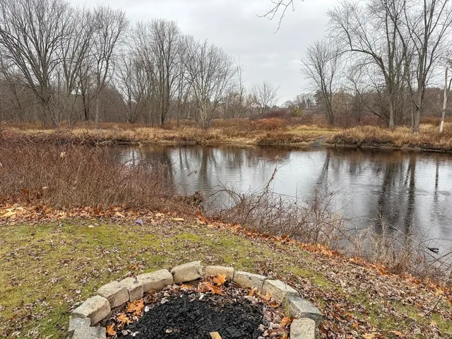 a view of a lake with a yard and covered trees