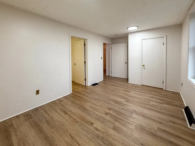 a view of an empty room and wooden floor