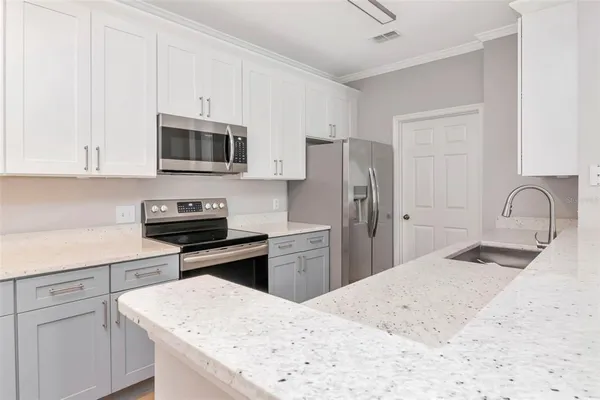 a kitchen with a refrigerator stove and white cabinets