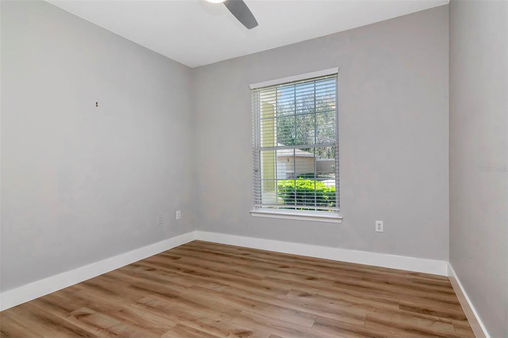 9916 Courtney Palms Boulevard, Unit 103 Tampa, FL 33619 - Photo 16 of 28 an empty room with wooden floor and windows