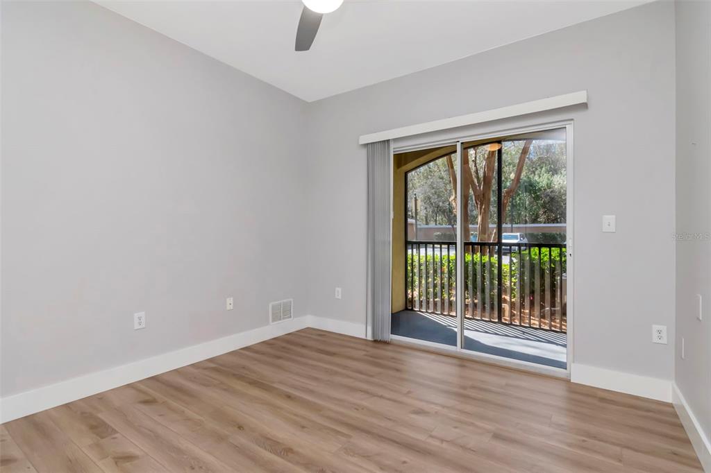 9916 Courtney Palms Boulevard, Unit 103 Tampa, FL 33619 - Photo 18 of 28 a view of an empty room with wooden floor and a window