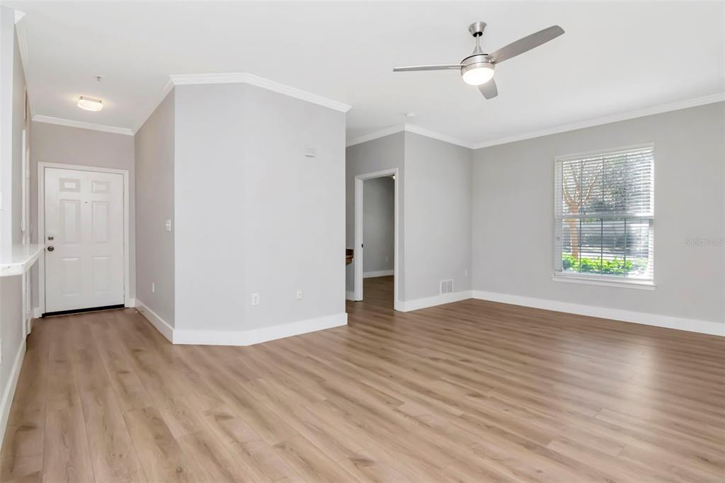 9916 Courtney Palms Boulevard, Unit 103 Tampa, FL 33619 - Photo 3 of 28 a view of an empty room with wooden floor and a window