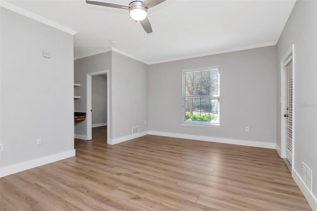 9916 Courtney Palms Boulevard, Unit 103 Tampa, FL 33619 - Photo 6 of 28 a view of an empty room with wooden floor and a window