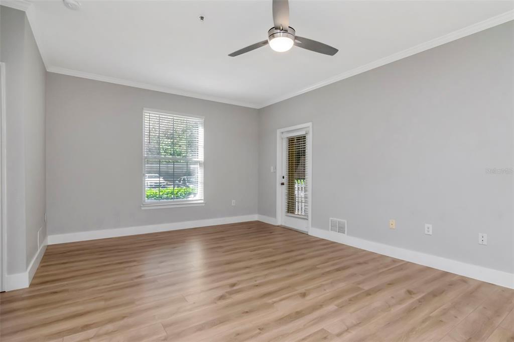 9916 Courtney Palms Boulevard, Unit 103 Tampa, FL 33619 - Photo 7 of 28 a view of an empty room with wooden floor and a window