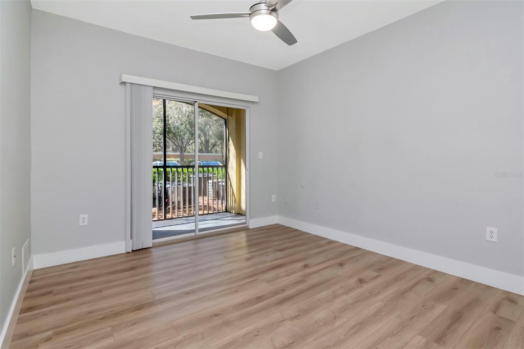 9916 Courtney Palms Boulevard, Unit 103 Tampa, FL 33619 - Photo 8 of 28 a view of an empty room with wooden floor and a window