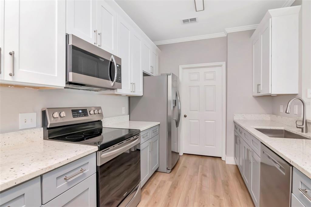 9916 Courtney Palms Boulevard, Unit 103 Tampa, FL 33619 - Photo 9 of 28 a kitchen with a sink stove and microwave