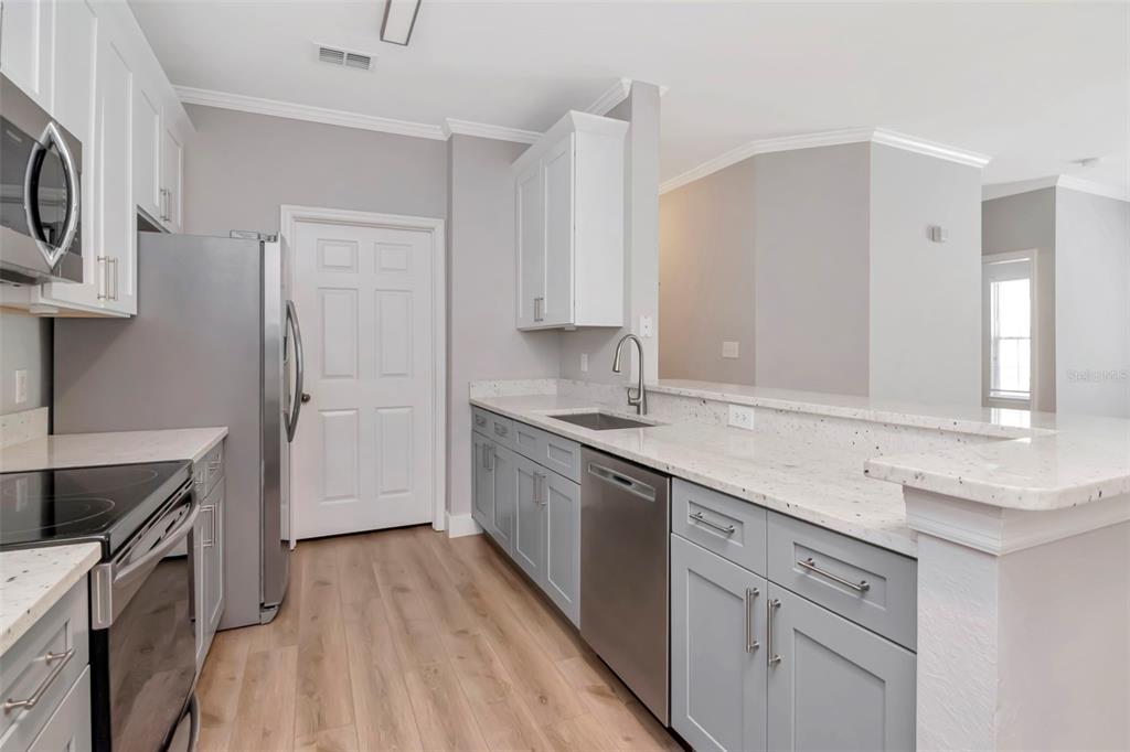 9916 Courtney Palms Boulevard, Unit 103 Tampa, FL 33619 - Photo 10 of 28 a kitchen with a sink stove top oven and cabinets