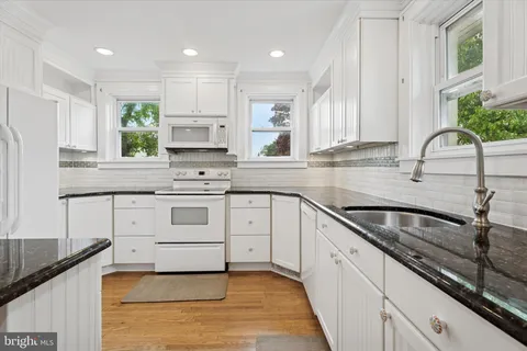 a kitchen with granite countertop a sink stainless steel appliances and cabinets