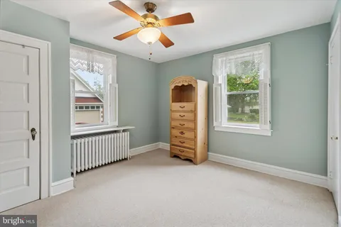 an empty room with windows and fan
