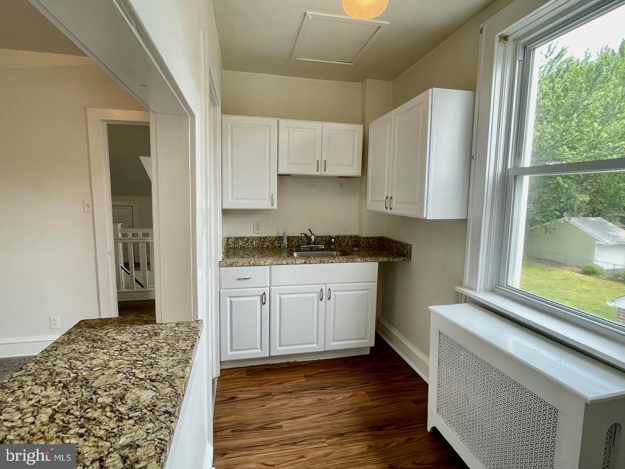 1442 Dorchester Road Havertown, PA 19083 - Photo 26 of 45 a kitchen with granite countertop white cabinets and wooden floor