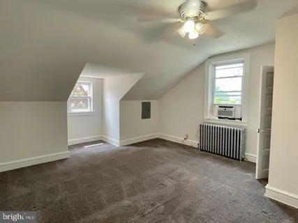 an empty room with windows and ceiling fan
