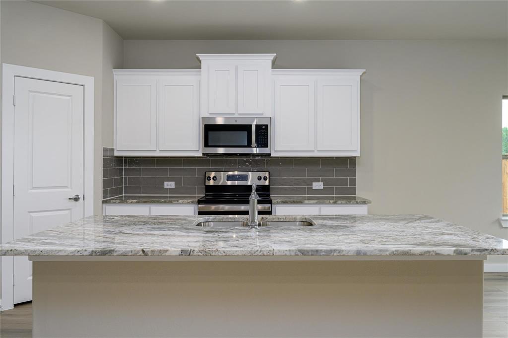412 Heritage Grove Road Blue Ridge, TX 75424 - Photo 4 of 20 a kitchen with kitchen island a sink a stove and cabinets