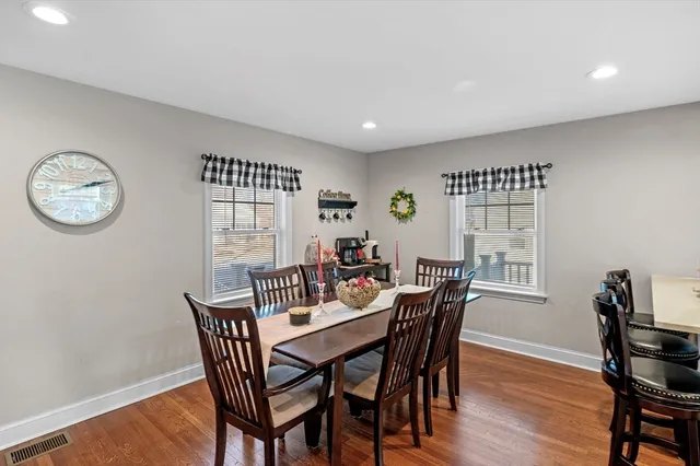 a view of a dining room with furniture a rug and wooden floor