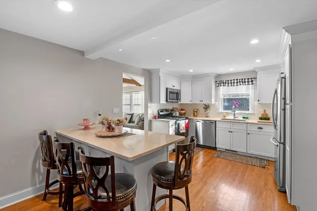 a open dining room with stainless steel appliances a table and chairs