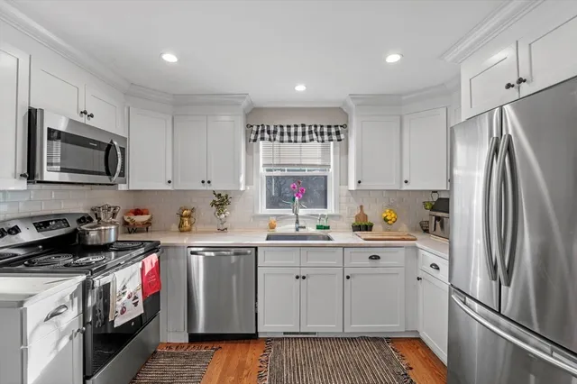 a kitchen with stainless steel appliances a stove a sink and a refrigerator