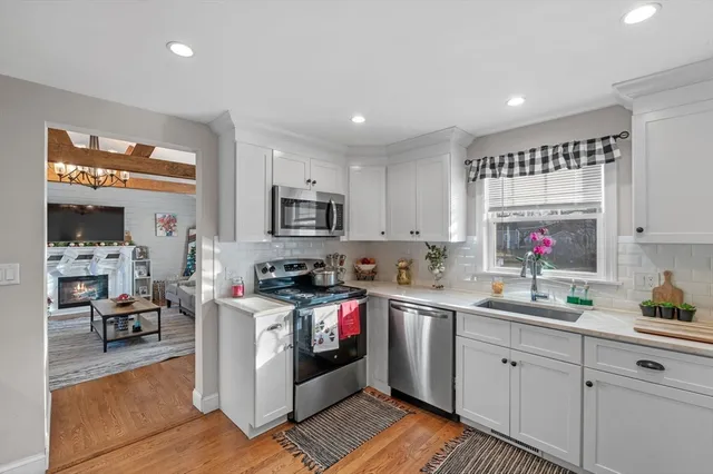 a kitchen with stainless steel appliances granite countertop a sink stove and cabinets