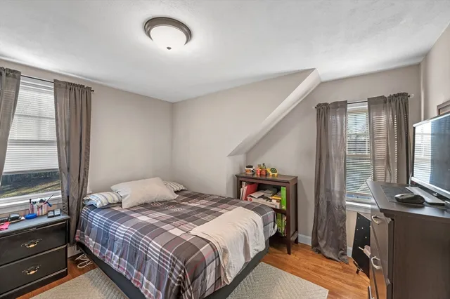 a bedroom with a bed and a flat tv screen on the dresser