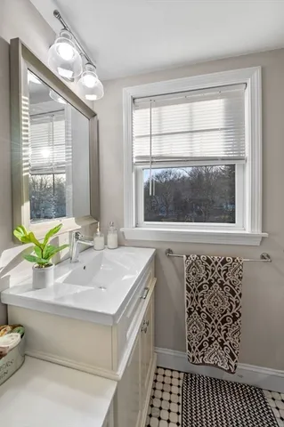 a bathroom with a sink a toilet and a window