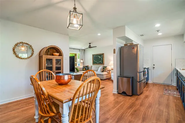 a dining room with furniture a chandelier and wooden floor