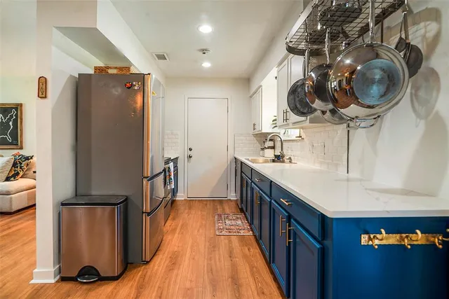 a kitchen with stainless steel appliances granite countertop a refrigerator a stove and a sink